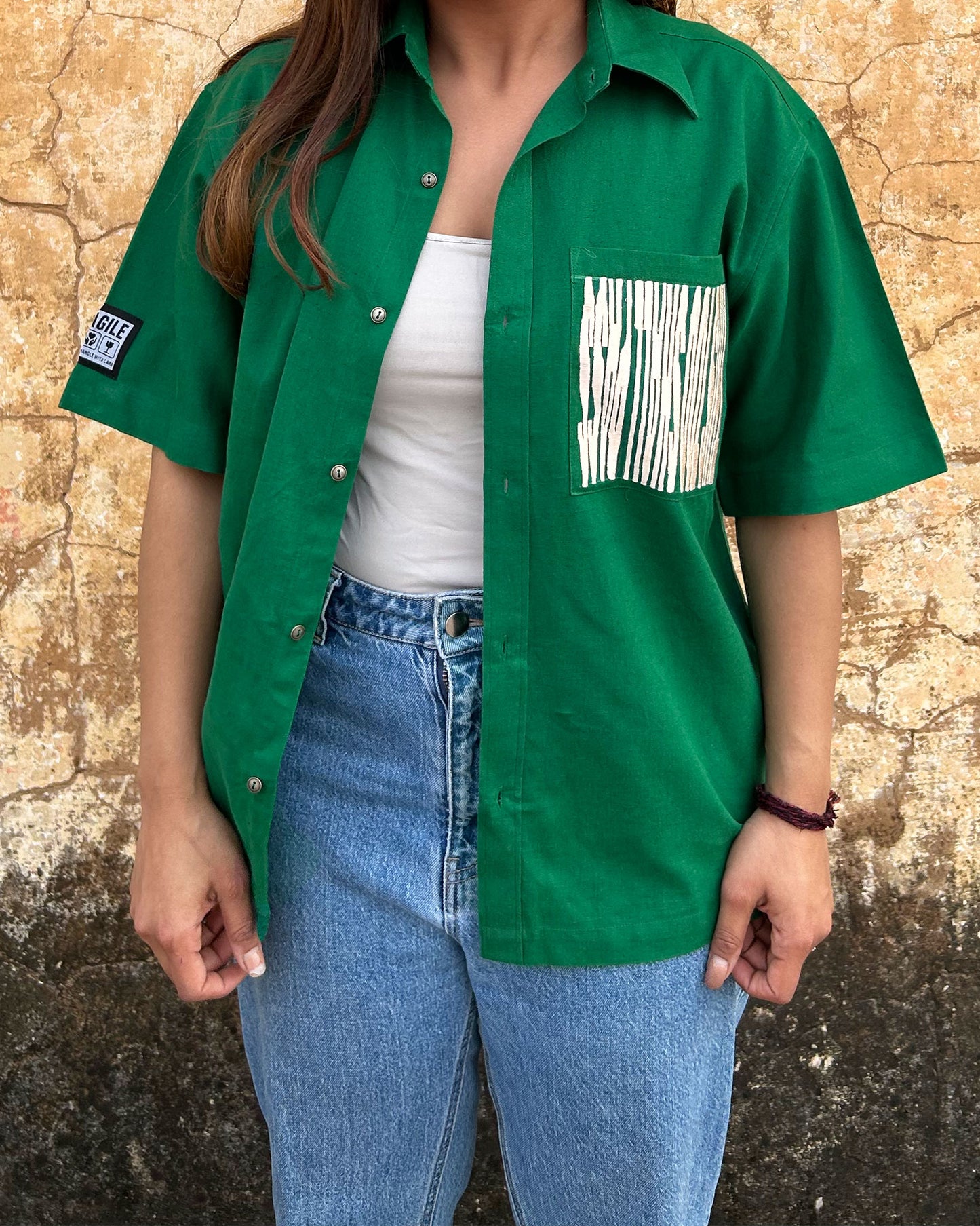Model wearing Silent Scream Green Shirt with Pink Embroidered Message